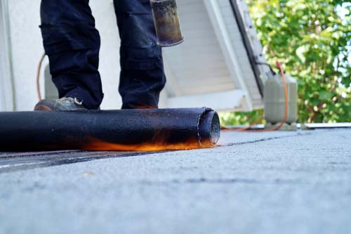 Tech rolling material onto roof